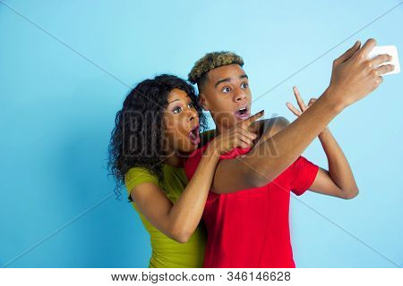 Taking Selfie Or Vlog Together. Young Emotional African-american Man And Woman In Colorful Clothes O