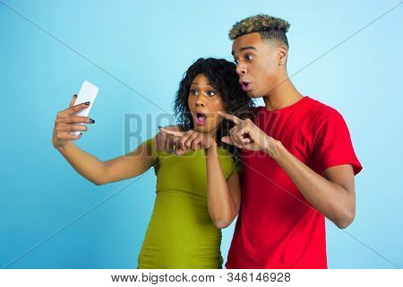 Taking Selfie Or Vlog Together. Young Emotional African-american Man And Woman In Colorful Clothes O