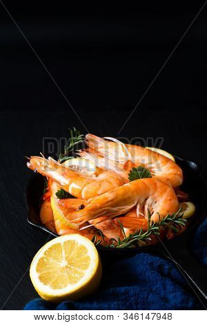 Seafood Concept Ocean King Prawns Cooked In Skillet Iron Cast On Black Slate Stone With Blue Napkins