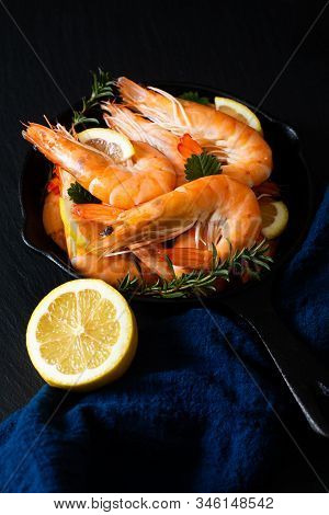 Seafood Concept Ocean King Prawns Cooked In Skillet Iron Cast On Black Slate Stone With Blue Napkins