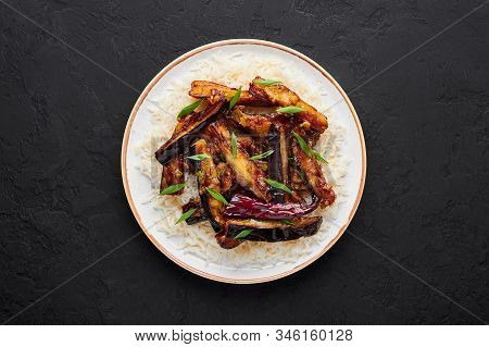 Sichuan Eggplant Stir Fry In Black Bowl At Dark Slate Background. Eggplant Stir Fry Is Chinese Cuisi