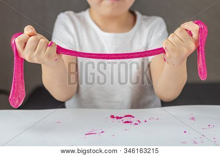 Kid Plays With A Homemade Pink Glitter Slime. Child  Hands Stretch Slime Toy. Make Slime At Home. Th