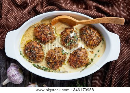 Rabbit Ballotine In A Creamy Mustard Sauce With Herbs And Spices In A Baking Dish On A Rustic Wooden