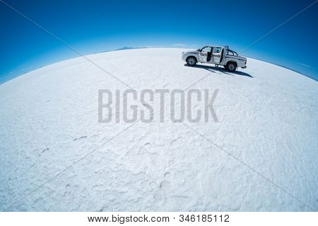 SALAR DE UYUNI / BOLIVIA APRIL 04, 2018: Off road car stays on the Uyuni salt flat during sunny day