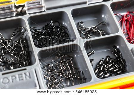 Opened Tackle Box With Fishing Hooks And Accessories. Fishing Hooks In Box Sections. Case For Tackle