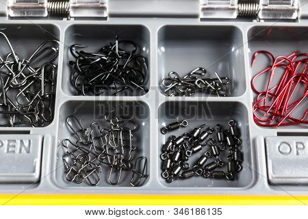 Opened Tackle Box With Fishing Hooks And Accessories. Fishing Hooks In Box Sections. Case For Tackle