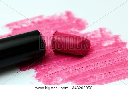 Broken Bright Pink Lipstick Lies On A White Background