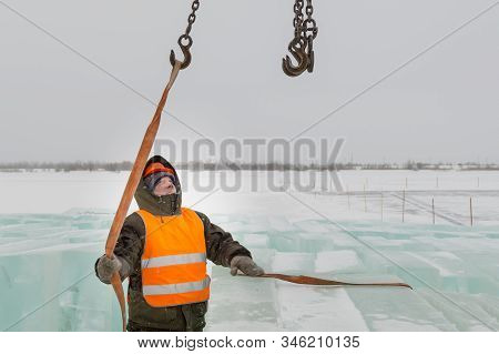 Slinger In Orange Helmet On Shipment Of Ice Blocks