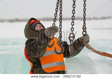 Slinger In Orange Helmet On Shipment Of Ice Blocks