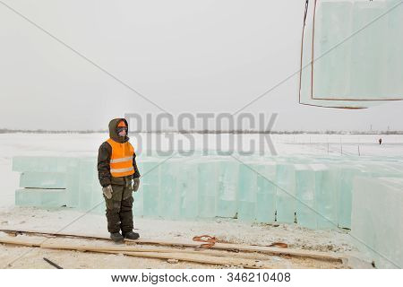 Slinger In Orange Helmet On Shipment Of Ice Blocks