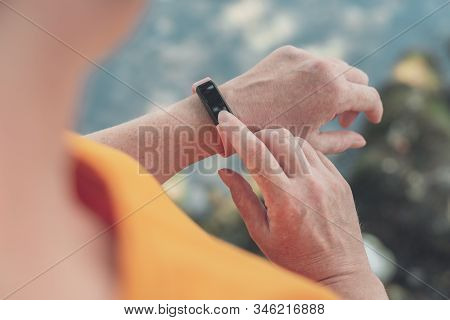 Woman Hiker Using Smart Bracelet During Trekking In Nature. Close Up Of Female Hands With Portable I