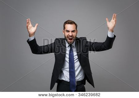 Angry Young Business Man In Classic Black Suit Shirt Tie Posing Isolated On Grey Background. Achieve