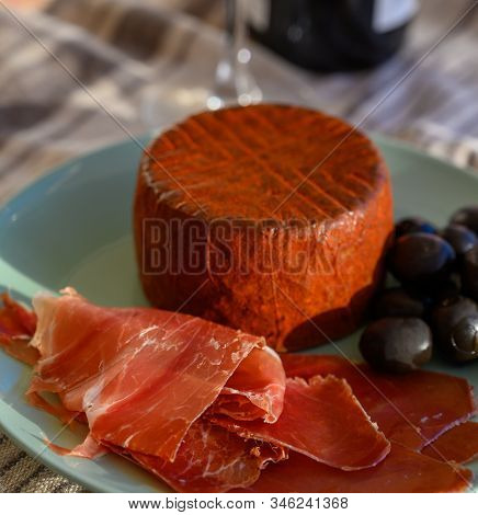 Tastes Of Spain, Jamon Iberian, Black Olives, Manchego Cheese With Red Paprika And Glass With Red Ri
