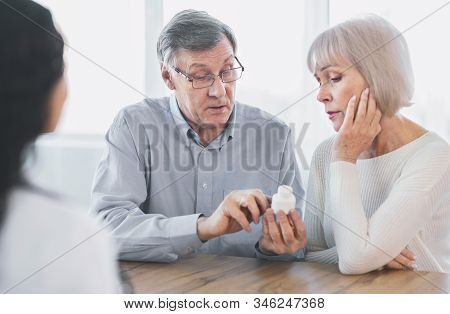 Prescription Medication. Confident Senior Man Pointing At Bottle, Reading Instructions, Asking Docto