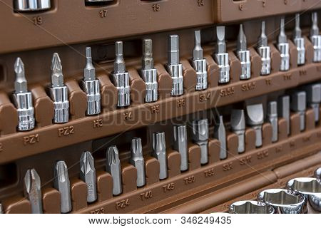 Set Of Metal Heads For Screwdriver In A Box. Abstract Tech Background.