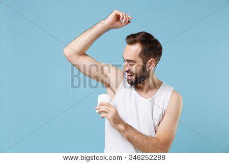 Bearded Young Man 20s Years Old In White Shirt Hold Using Antiperspirant Isolated On Blue Pastel Wal