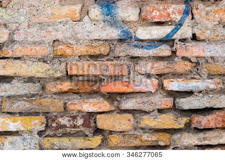 An Red Brick Wall With A Blue Dashin The Old Town Of Vilnius, Lithuania. Texture Of Old Masonry. Clo