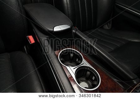 Interior View With Leather Seats And Two Cupholders And Armrest Of Black Used Car Stands In The Show