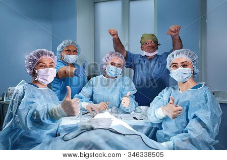 Group Of Professional Doctors Surgeons Over The Clinic Background In Oparation Room Smiling Looking 