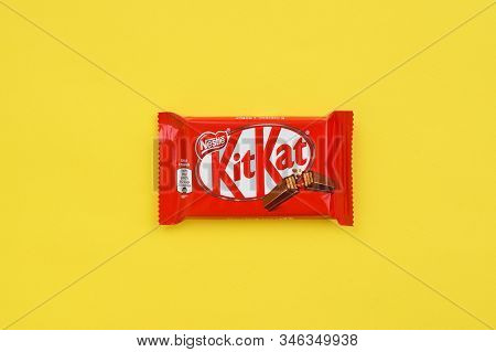 Kit Kat Chocolate Bar In Red Wrapping Lies On Yellow Background. Kit Kat Created By Rowntrees Of Yor