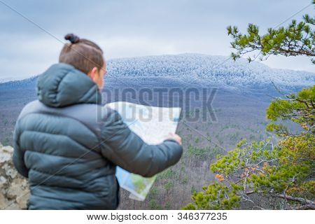 Well-dressed Man Working With Laptop Sitting On The Rocky Mountain On Beautiful Scenic Clif Backgrou