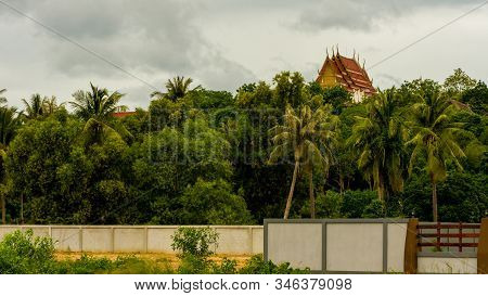 Thai Temple Rising Above The Trees And Wall In Pak Nam Pran, Pranburi Thailand