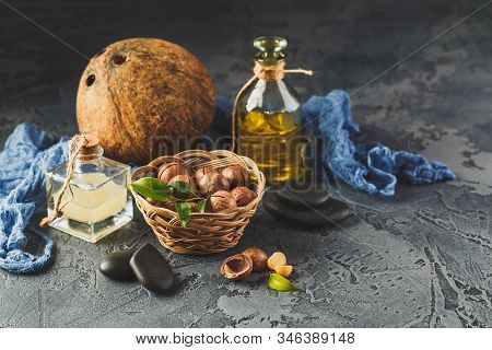 Natural Macadamia And Coconut Oil In A Glass Bottles With Macadamia Nuts And Cocnut. Use For Healthy