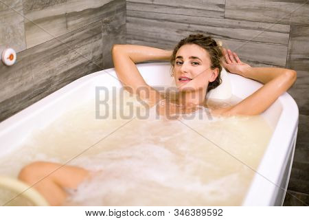 Charming Smiling Woman Relaxing In The Bathtub Having A Hydromassage Therapy In The Spa Center