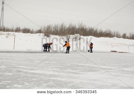 Workers Rafting Ice Blocks Along A Channel Cut Out By A Frozen Lake