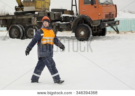 Slinger In An Orange Helmet Walks Down The Assembly Site