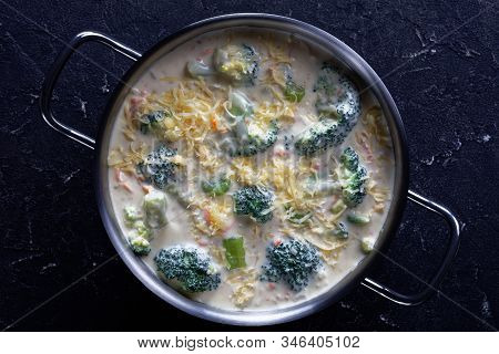Broccoli And Cheddar Cheese Soup In A Stewpan On A Concrete Table, Horizontal View From Above,  Clos
