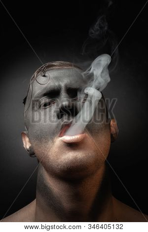 Close-up Portrait Of A Handsome Guy In Makeup Blows Smoke. Stock Art Photo Of A Smoker.