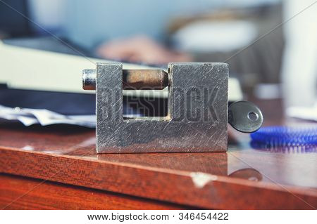 Lock With Key On The Wooden Desk Background