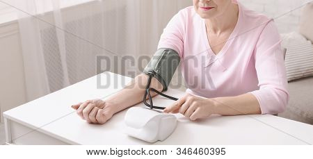 Hypertension. Mature Woman Checking Her Blood Pressure With Tonometer At Home, Panorama With Free Sp