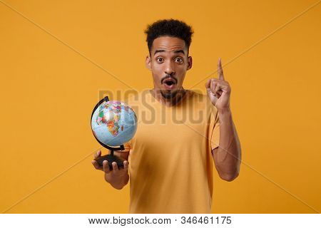 Young African American Guy In Casual T-shirt Posing Isolated On Yellow Orange Background. People Lif