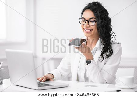 Voice Search. Mexican Businesswoman Using Smart Phone Voice Recognition To Send Message At Workplace