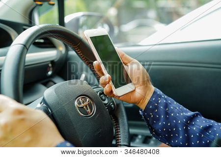 Bangkok, Thailand - February 25, 2019: Holding Iphone In Toyota Sienta Car To Communication With Fam