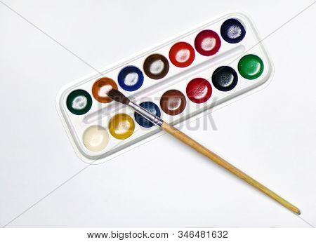 Top View Of Paint With A Brush. A Box Of Watercolor Paints With A Paint Brush Is Isolated On A White