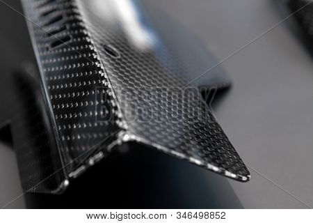 A Close-up On A Car Exterior Elements Made From Carbon Fiber Of Interwoven Black And Gray Color From