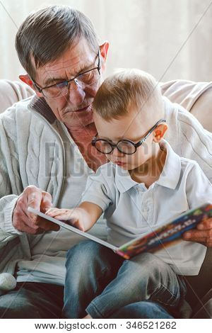 Grandfather And Grandson Are Reading A Book
