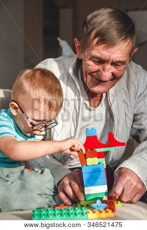 Elderly Grandpa Or Grandfather Plays With His Little Grandson