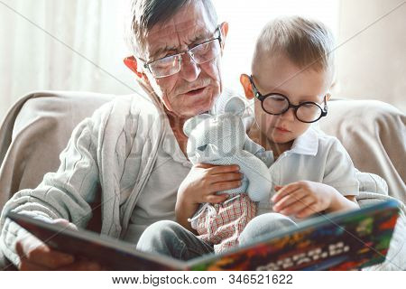 Grandfather And Grandson Are Reading A Book