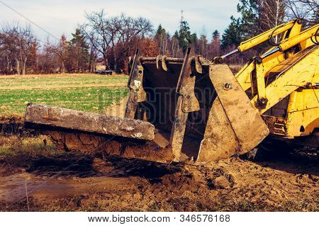 The Yellow Excavator Transports Concrete Slabs In The Countryside.