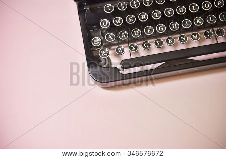 Vintage Black Typewriter Keyboard On Solid Pink Background