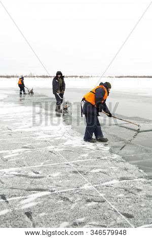 Worker Rafts Ice Blocks Along A Canal Carved In A Frozen Lake