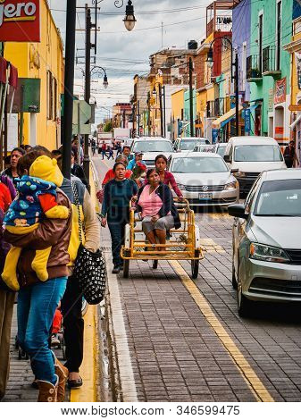 San Pedro Cholula, Mexico, October 17, 2018 - Street Scene: Two Young Women Push A Tricycle With An 