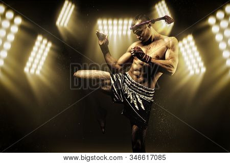Kickboxer In The Ring Surrounded By Searchlights Stretches Before The Fight. Makes Swing Movements W