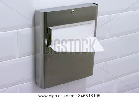 Paper Towel Dispenser Is Hanging On The Wall In The Water Closet Room. Concept Of Self Hygiene, Clea