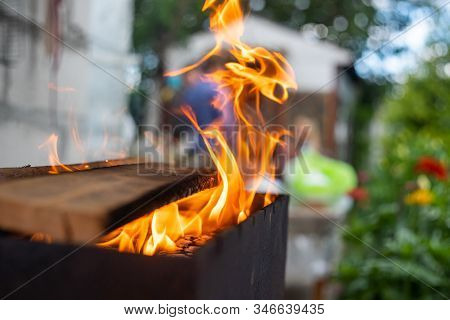 B-b-q Outdoors Background. Kindling Wood Barbecue Outdoors With Open Flame Against The Background Of