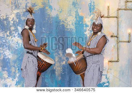 A Group Of People In Traditional African Costumes Playing Jembe Drums